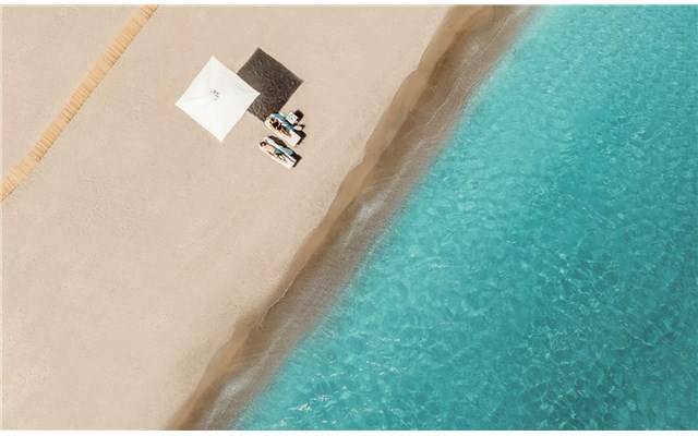 Couple relaxing on the beach Ikos Aria